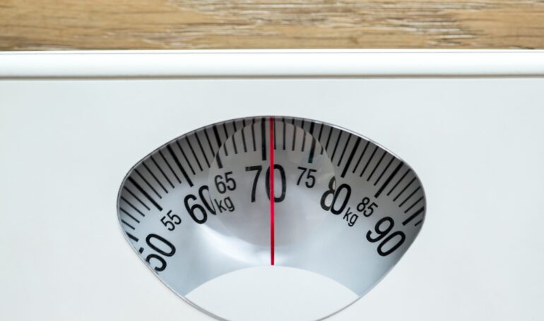 Closeup of weight scales overweight and obesity concept